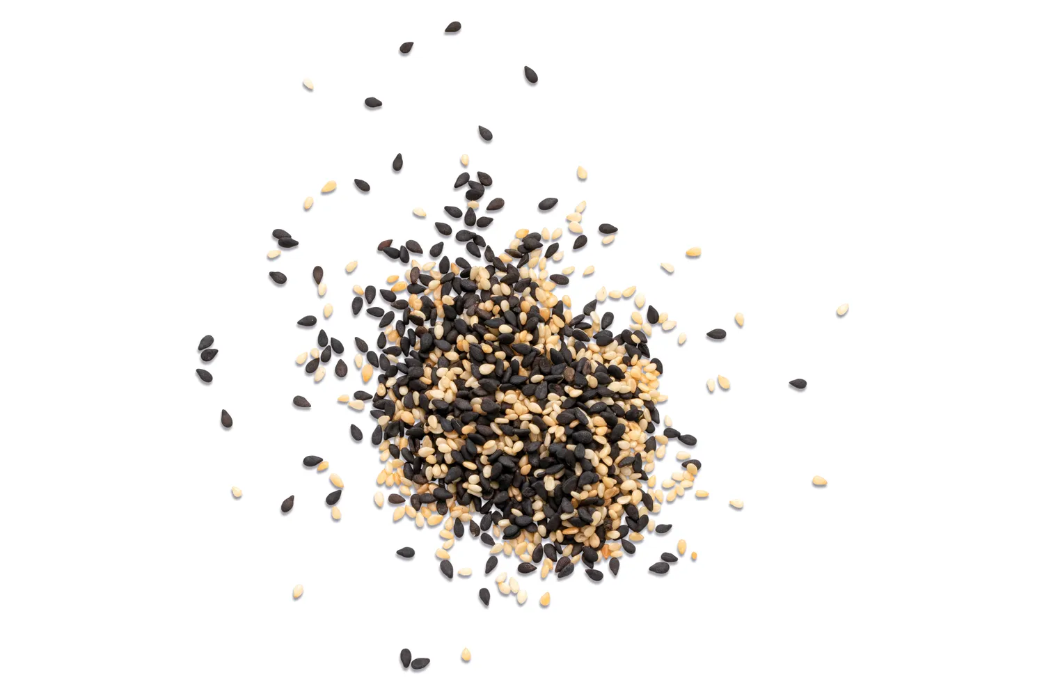 A pile of black and white sesame seeds scattered on a white background