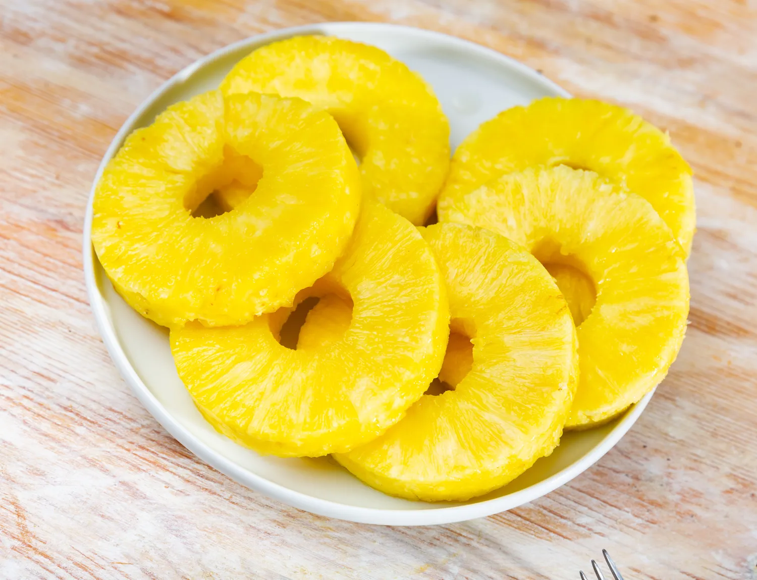 A plate containing several pineapple slices arranged neatly