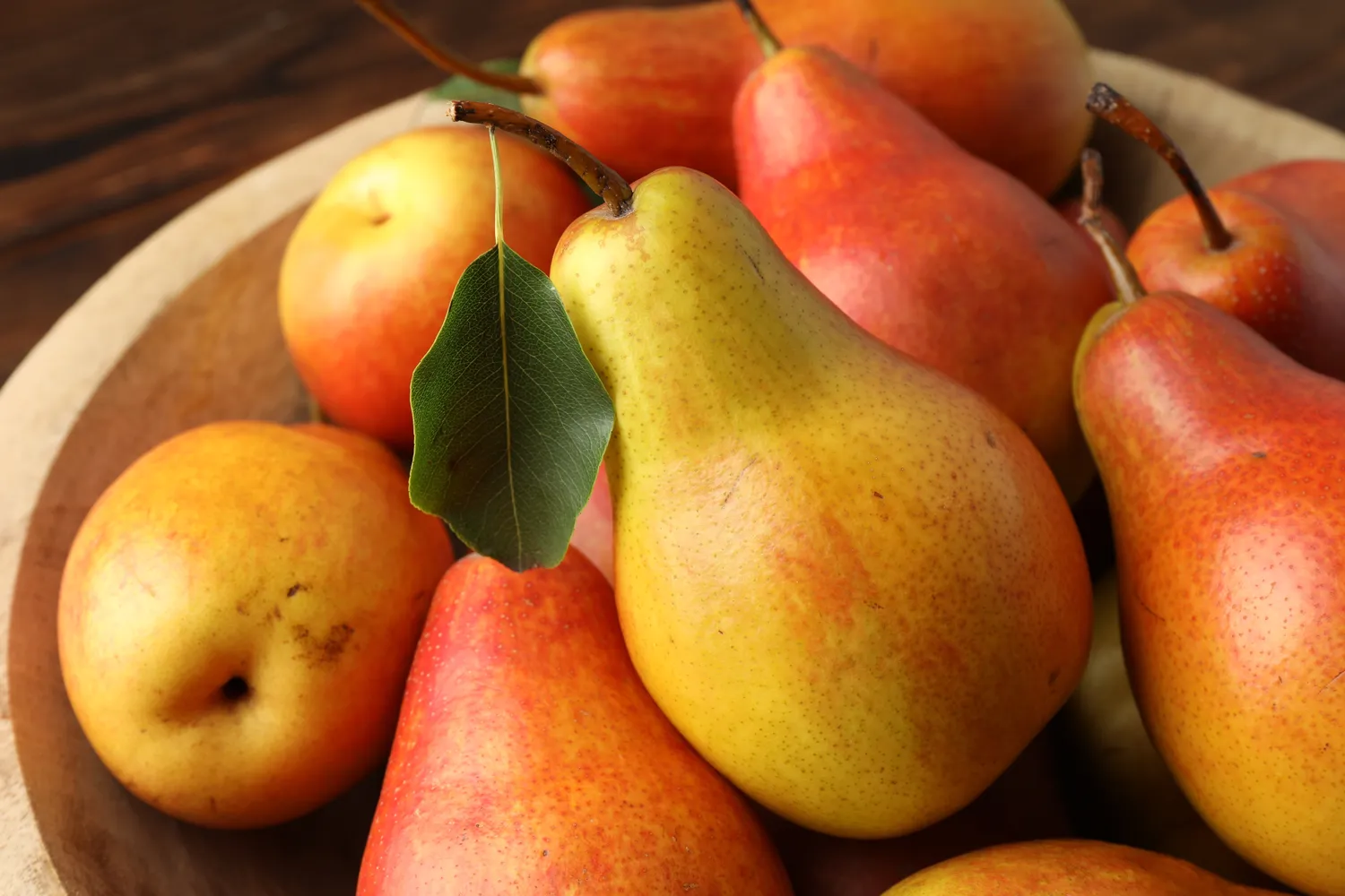 A wooden bowl filled with pears